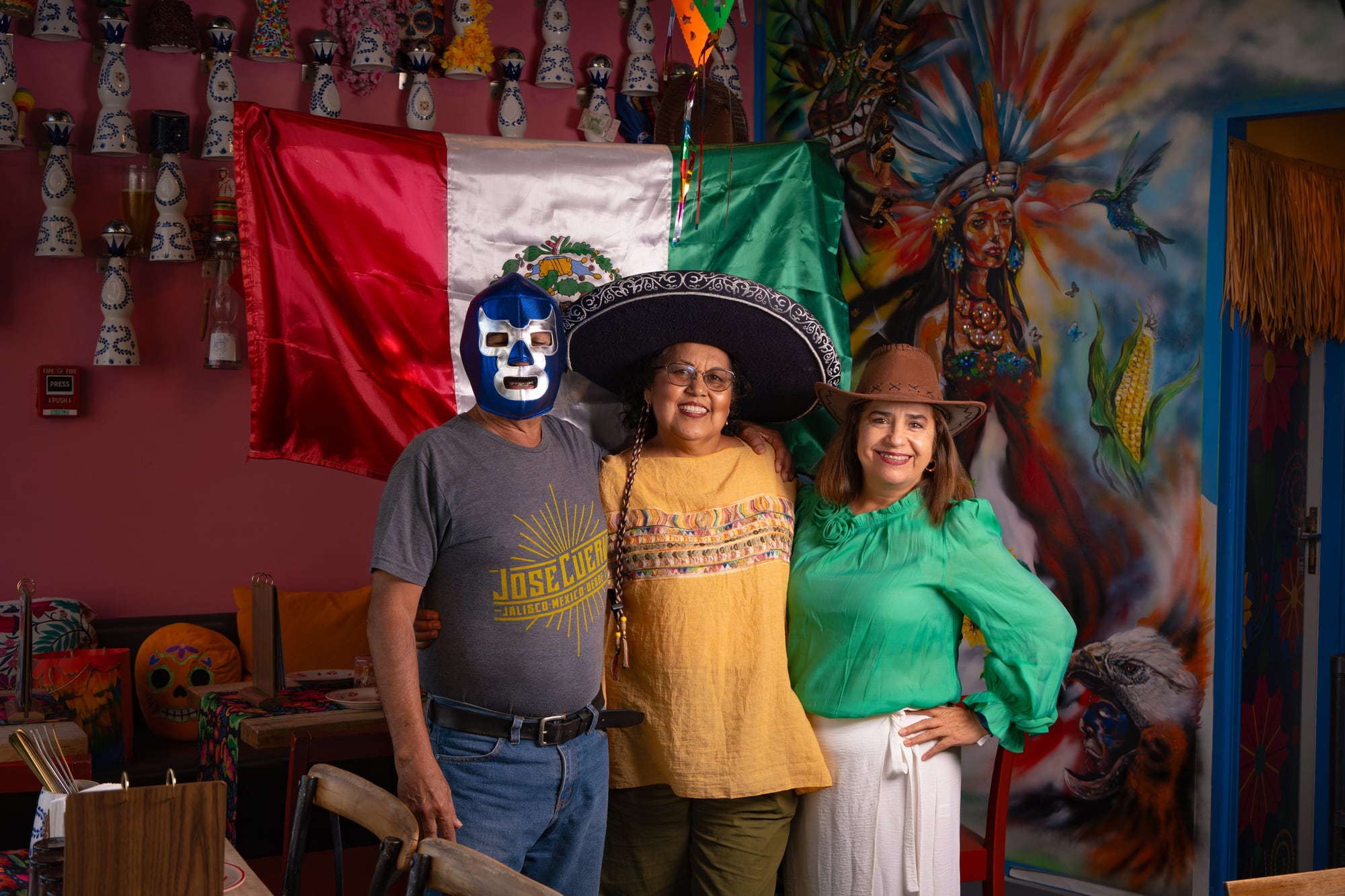 Mama Lalis in the lucha-libre sombrero, with the family — the Querida room, all in